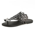 Black rhinestone flat thong sandal, side view, with ornate cutwork and butterfly detail