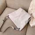 Ivory shoulder bag with adjustable strap and ring hardware, soft slouch shape