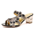 Peep-toe chunky heel sandals in black and gold with rhinestone clover ornament