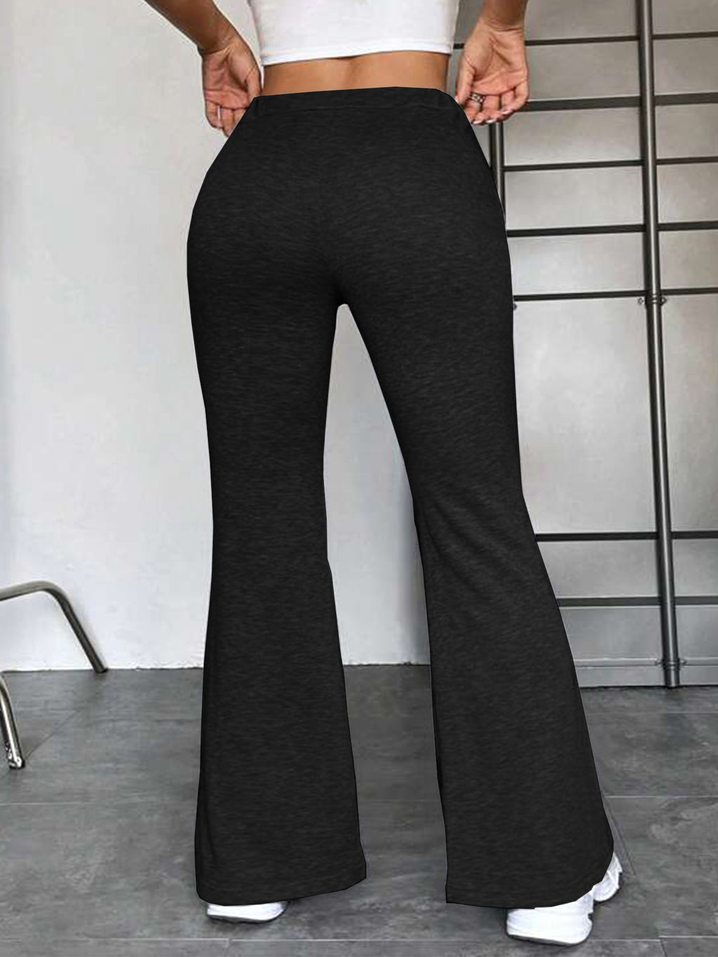 Black high-rise flared pants with drawstring waist and wide bell bottom.