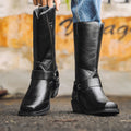 Black western cowboy boots with square toe and chunky heel, slip-on design with strap.