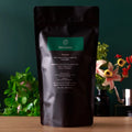 Emerald green tea pouch with Rare Leaves label on dark bag