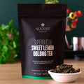 Black tea pouch with green oolong tea leaves in a white bowl