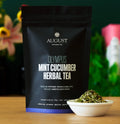 Caffeine-free mint cucumber herbal tea pouch with bowl of dried tea leaves
