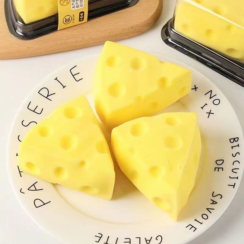 Three yellow cheese wedge squishy toys with round holes