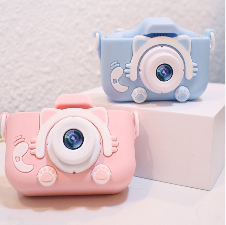 Children's digital camera toy, pink and light blue, with large round lens and cartoon paw details