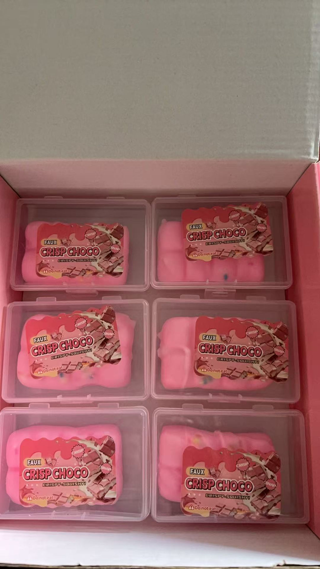 Close-up of pink-toned faux chocolate squeeze toys in clear box compartments