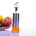 Glass oil dispenser bottle with white pump top, metal-look body and amber liquid