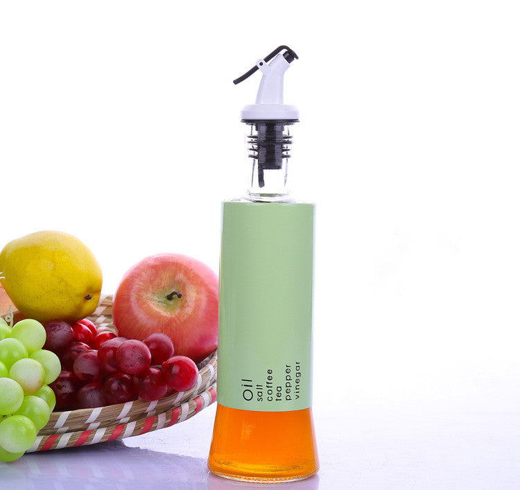 Glass oil dispenser bottle with white pump top, green body and amber liquid base