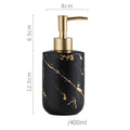 Marble-pattern dispenser bottle with gold pump; black bottle with golden marble veining