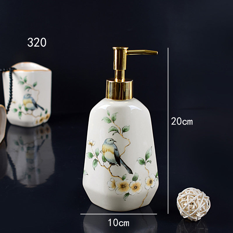 Hand-painted ceramic dispenser bottle, white with bird and flowers, gold pump, rounded shape