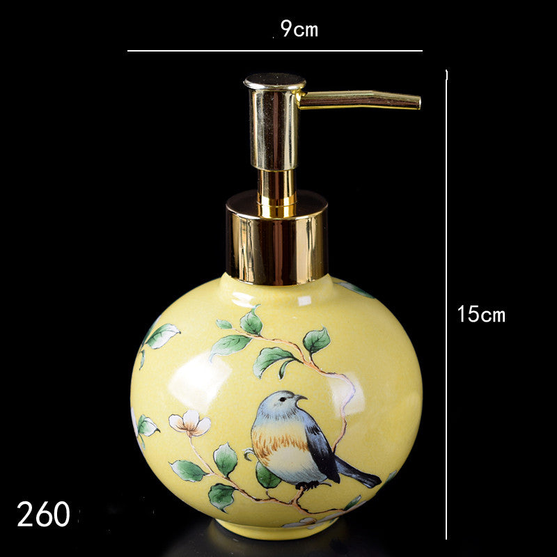 Hand-painted ceramic lotion/soap dispenser bottle, round yellow with bird and gold pump