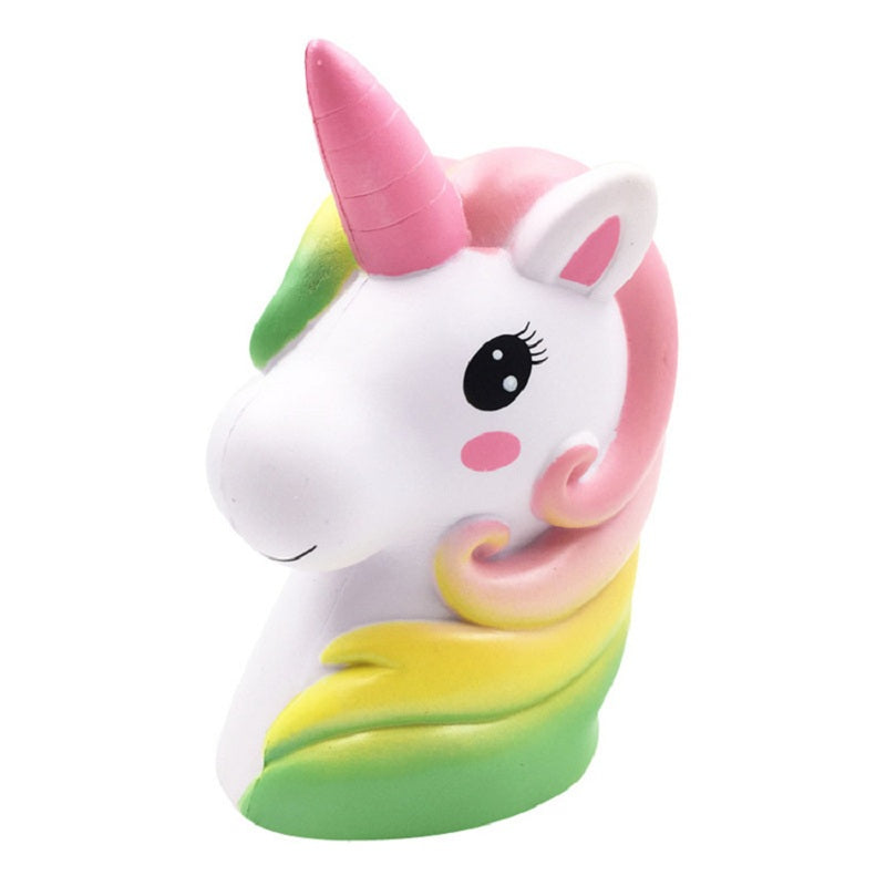Cute unicorn plush toy with white face, pink horn, rainbow mane, smiling expression.