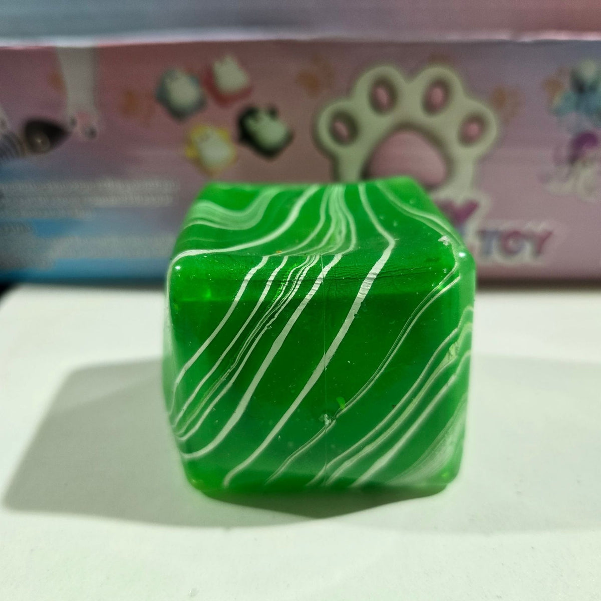 Green water-cube stress-relief squishy toy with white wavy stripes, translucent