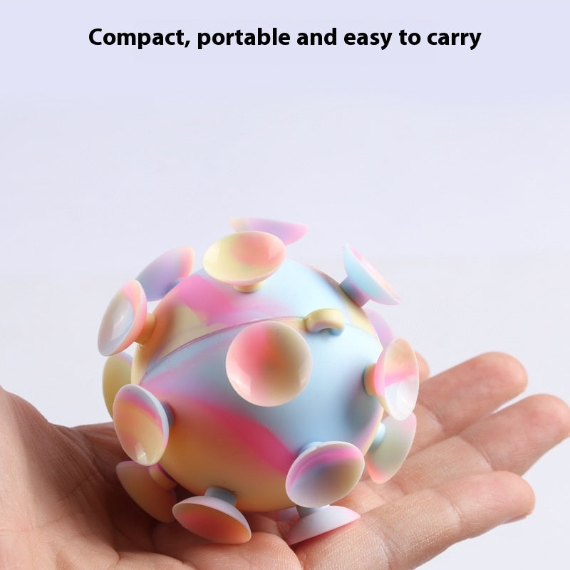 Silicone stress relief ball with pastel rainbow lobes, held in a hand