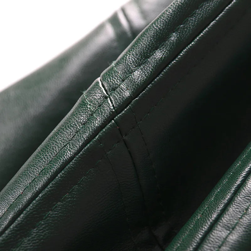 High-waist leather skirt close-up, dark green textured leather with seam lines