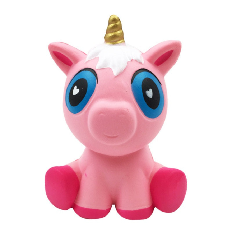 Pink pig plush toy with blue heart-pattern eyes, golden horn, and rounded snout.