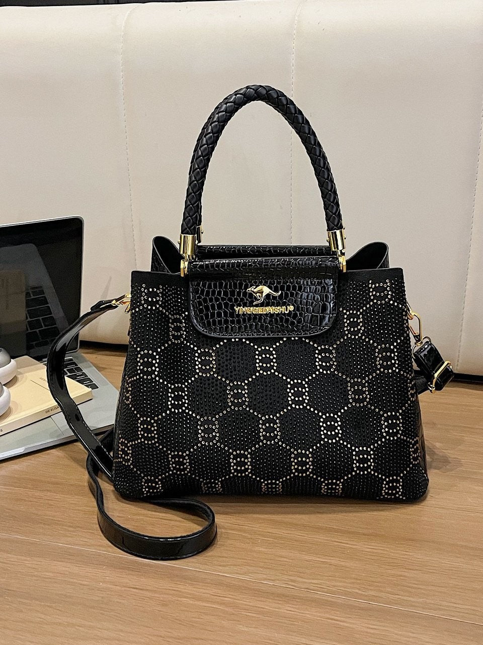 Black structured PU shoulder bag with front flap, top handles, and crossbody strap