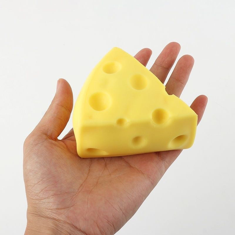 Yellow cheese wedge squishy toy with round holes held up in an open hand