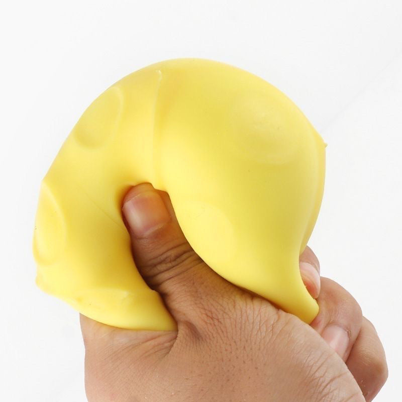 Yellow cheese wedge squishy toy being squeezed by a hand, soft and stretchy
