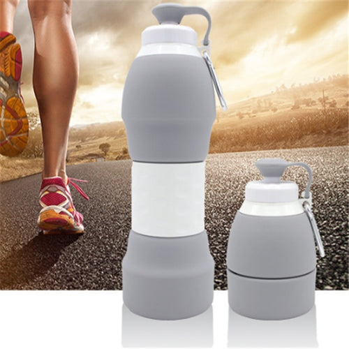 Grey collapsible silicone water bottle with white foldable body and carabiner loop
