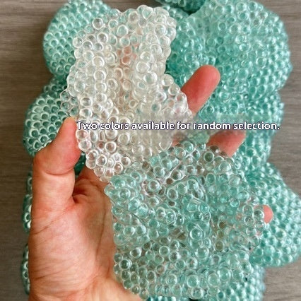Assorted textured stress-relief balls, mint-green and clear, shown in hands