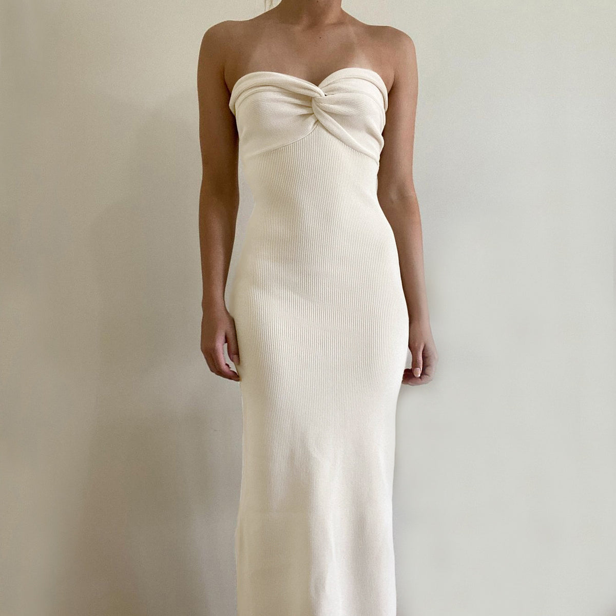 Cream off-shoulder knit long dress, front view with knotted bust and smooth column fit.