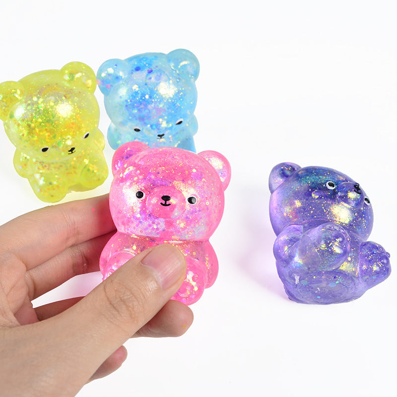 Hand holding pink translucent glitter maltose bear stress toy with yellow and purple bears