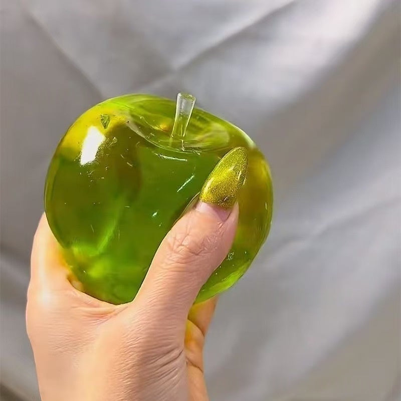 Green translucent apple stress squeeze toy with stem, close-up in hand