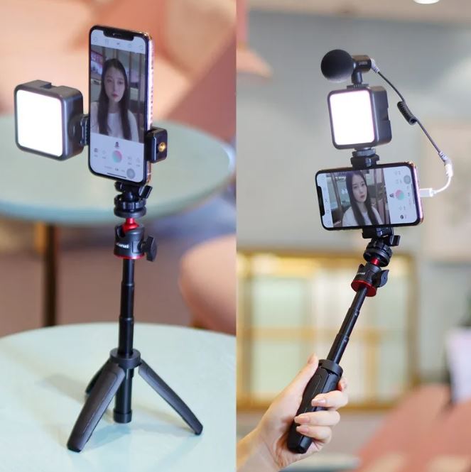 Black selfie stick with LED fill light; phone mounted on a tripod-style base