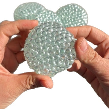 Clear textured stress-relief ball with bubbled surface, held up