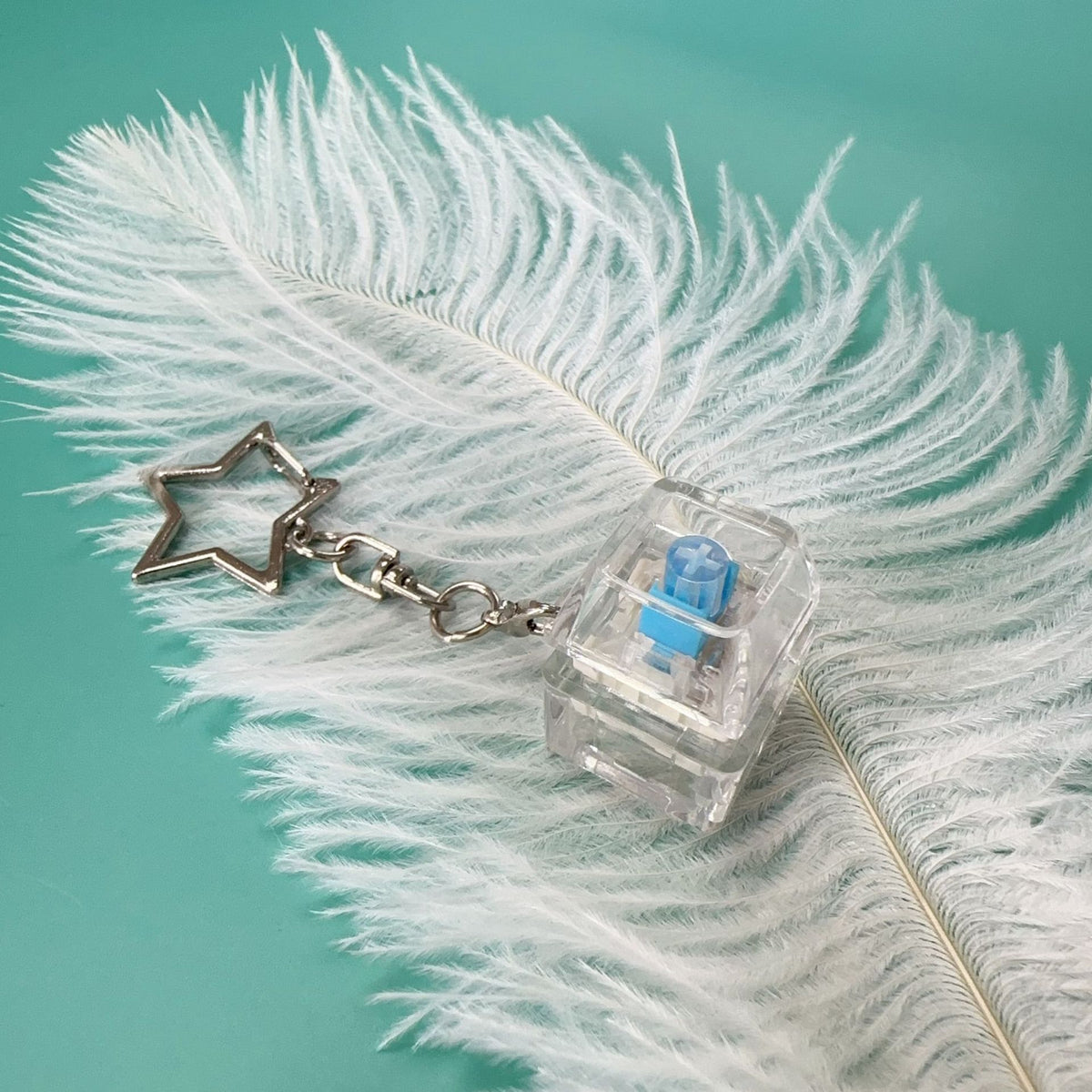 Clear mechanical key stress-relief toy with blue switch and star charm keychain