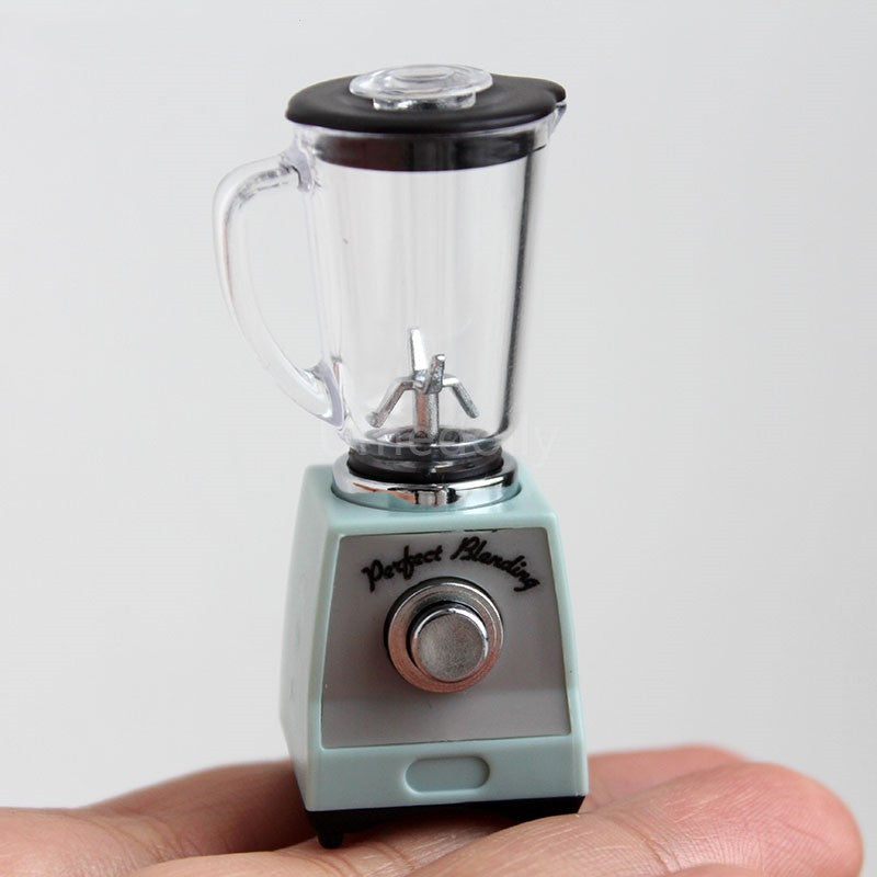 Light blue toy blender close-up with clear jar, black lid, and front dial