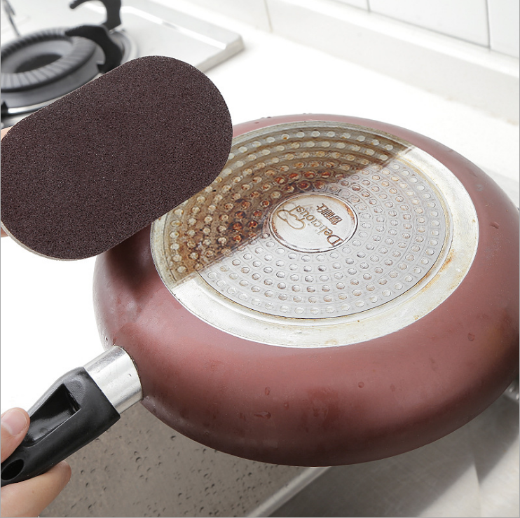 Emery cleaning tool pad lifted while scrubbing a pan surface