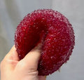 Red textured bayberry squishy stress toy, opened top view held in hand
