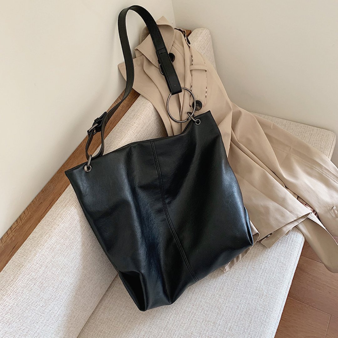 Black leather-look shoulder bag with wide strap and top zipper closure