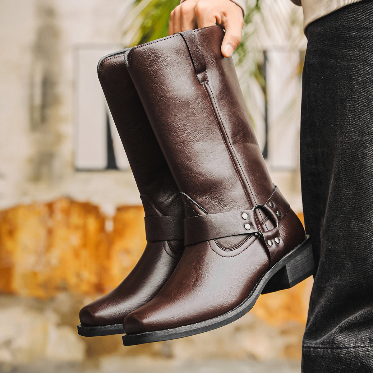 Dark brown cowboy boots, square toe, chunky heel, slip-on design with buckle strap.