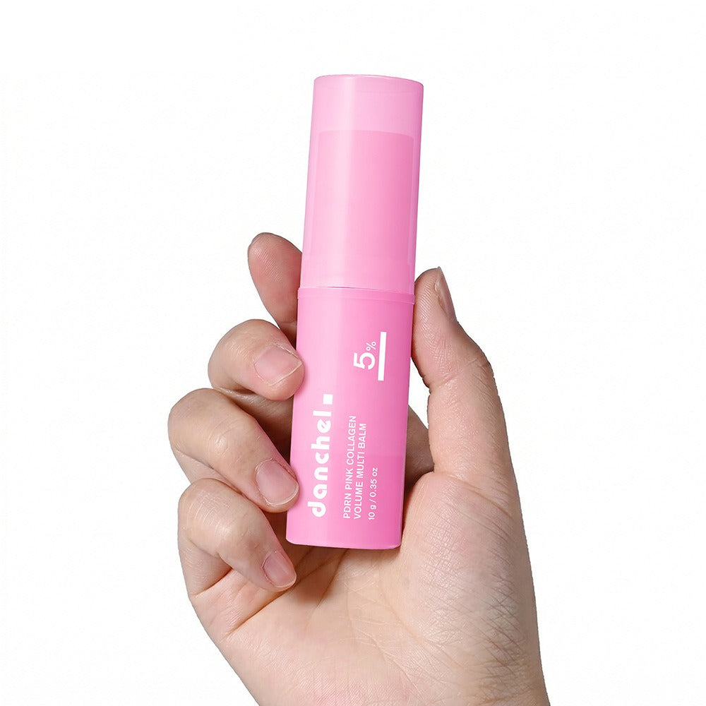 Pink collagen balm stick held by a hand, cylindrical tube with cap