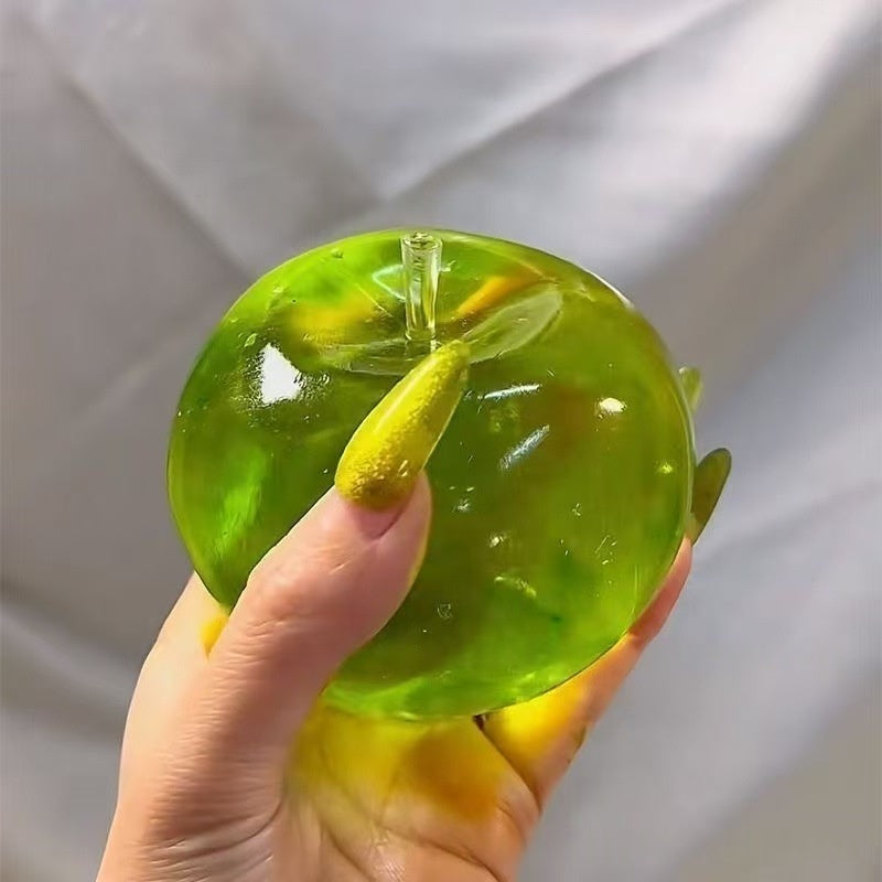Green translucent apple stress squeeze toy with small droplet detail, held in hand