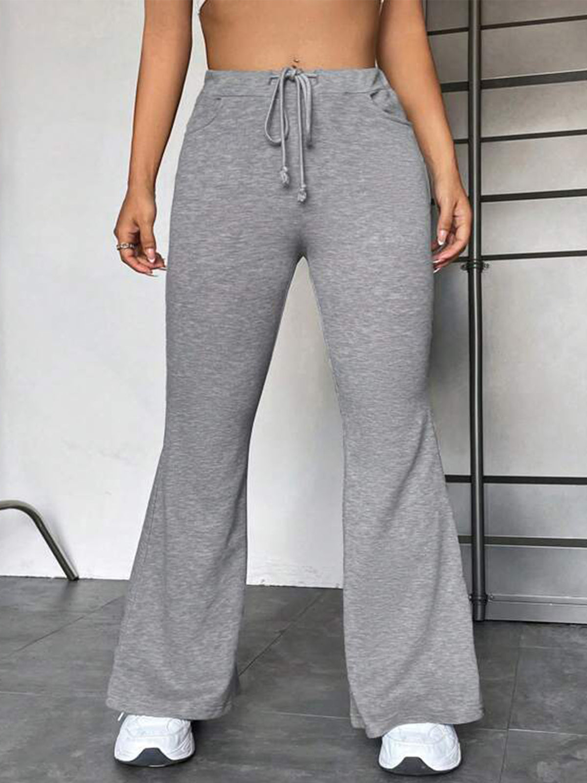 Gray wide-leg flared yoga pants with drawstring at the waist, full length.