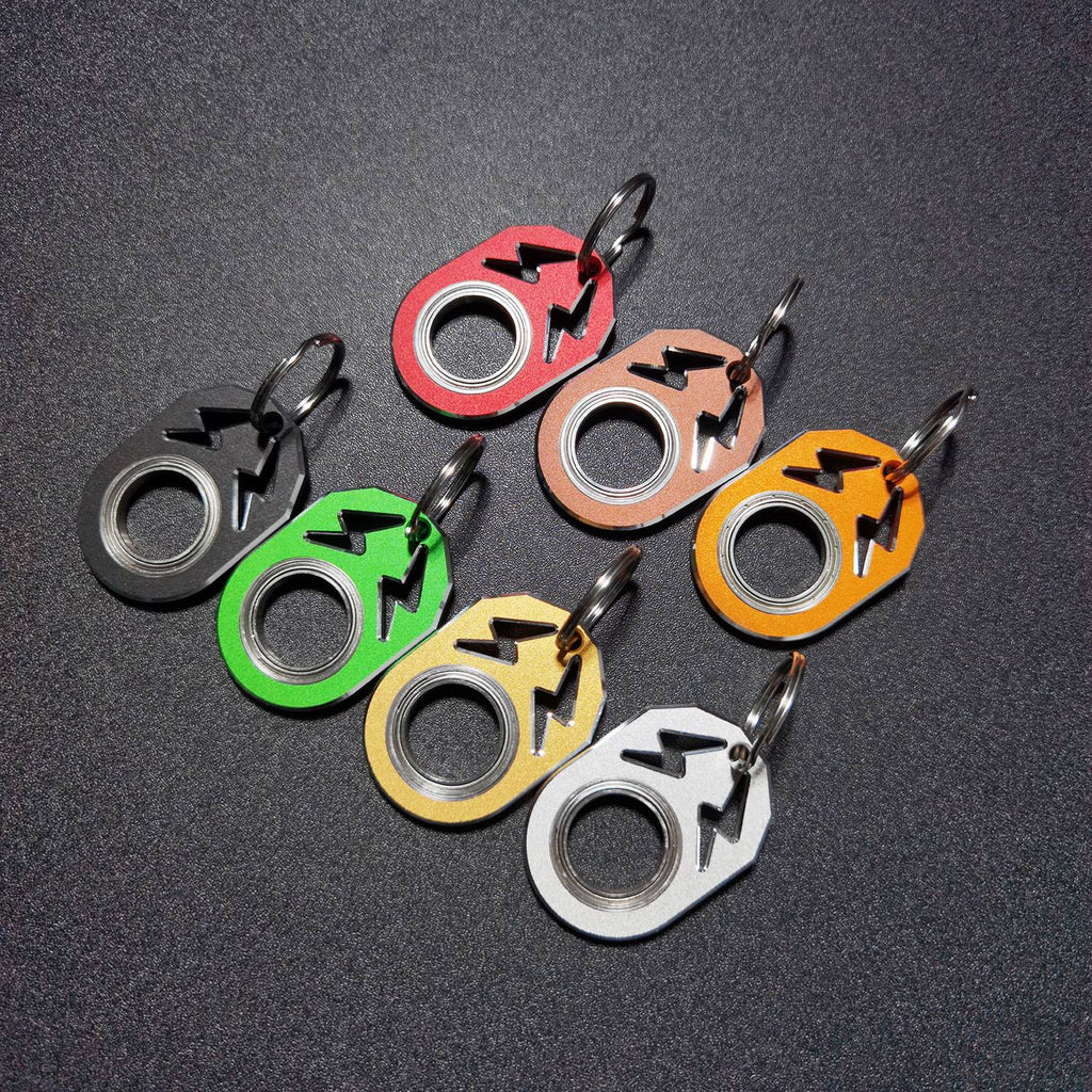 Assorted color rotating key chains with metal rings and arrow-style hooks.