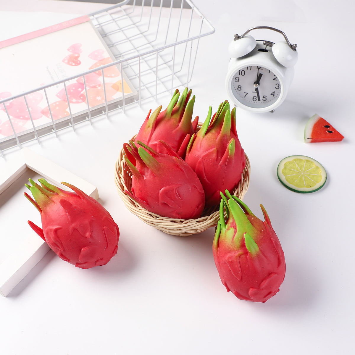 Set of red dragon fruit stress-relief gag toys with green leafy tops in basket