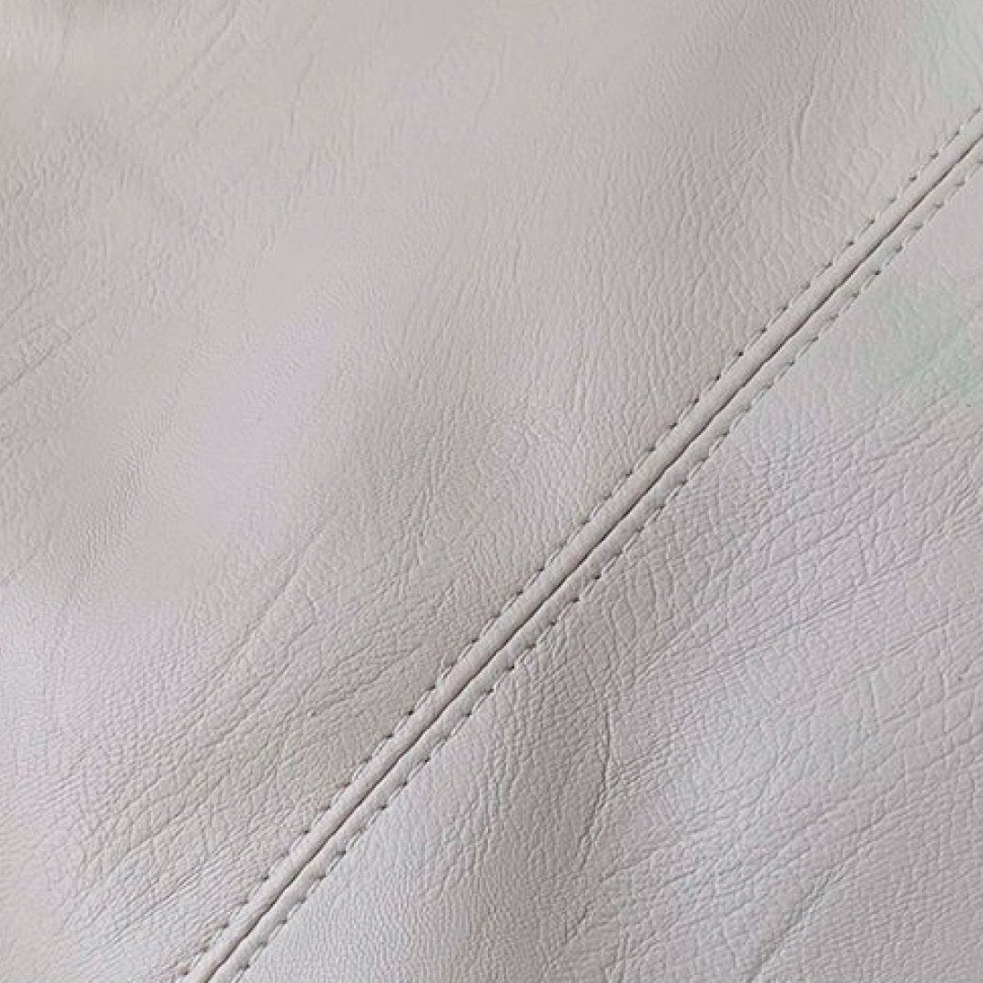 Ivory pebbled leather texture with visible stitched seam on shoulder bag
