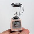 Peach toy blender close-up with clear jar, black lid, and front dial on base