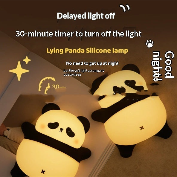 Lying panda silicone night light showing warm glow, two panda lamps on bed
