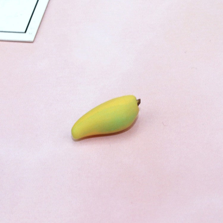 Yellow toy banana piece with stem nub on a light background
