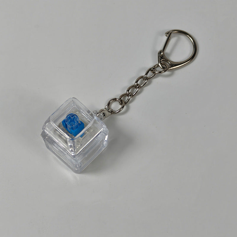 Clear cube stress-relief keychain toy with blue finger-popping button and metal chain