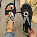 Women’s open-toe flat sandals in black with elastic straps and metal ring ornament, close-up
