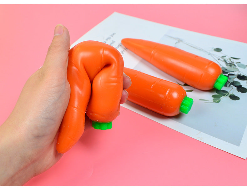 Orange carrot stress relief toy set with green caps, held in a hand