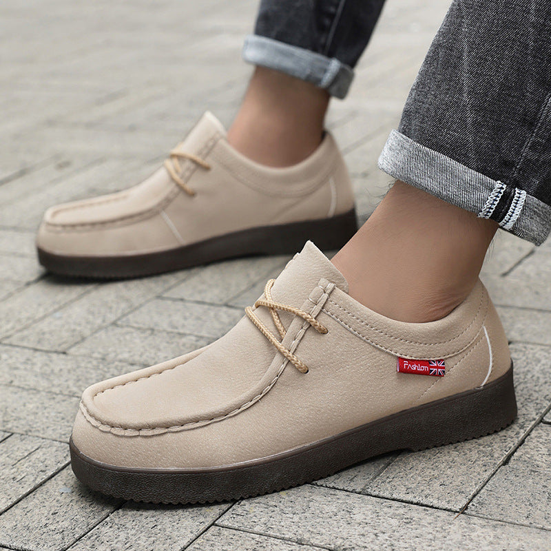 Beige suede lace-up loafer on foot with dark sole; worn with rolled jeans.